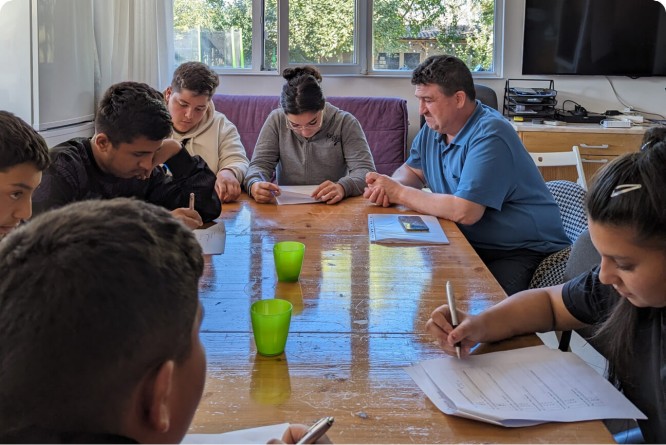 A diverse group of people passionately writing around a table, supporting Stepic Charity CEE's mission.