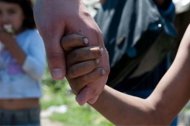 A heartwarming image of a child holding hands with a person, showing care and support.